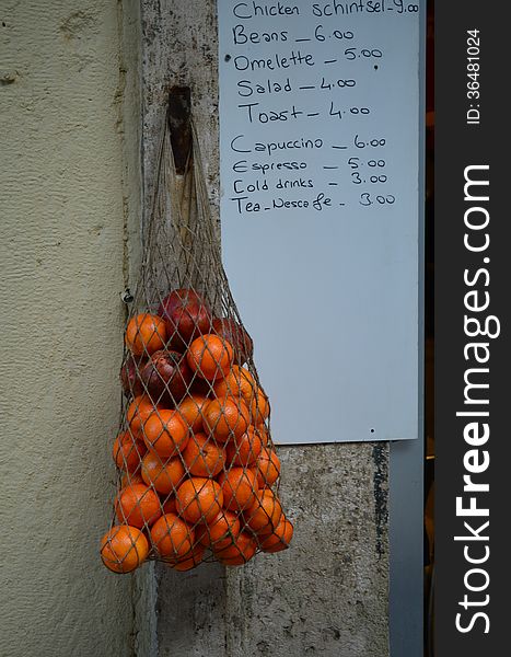 Oranges in a sack for sale hanged on a wall