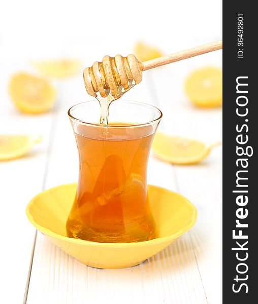 Tea with honey and lemon on a light wooden background