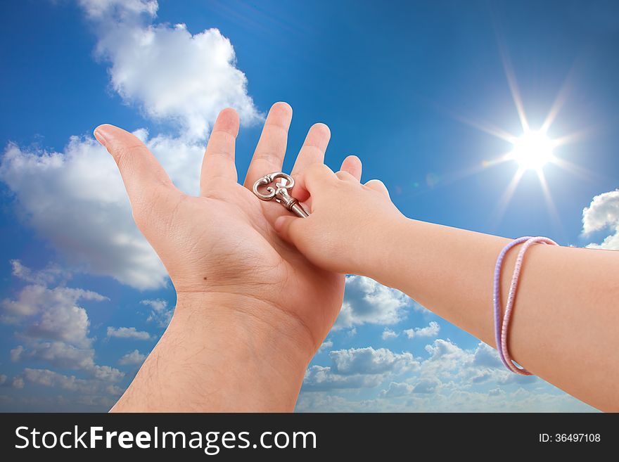 Father give son key on sunny sky background