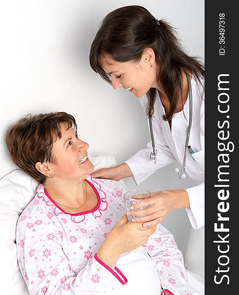 Nurse gives a glass of water to the patient