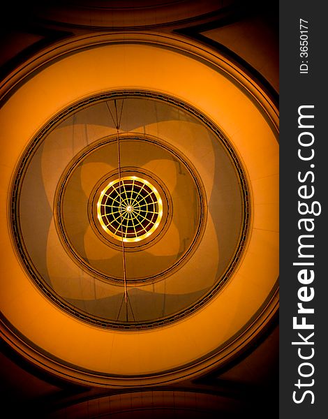 Orange abstract roof with circular design looking upward in low light. Orange abstract roof with circular design looking upward in low light