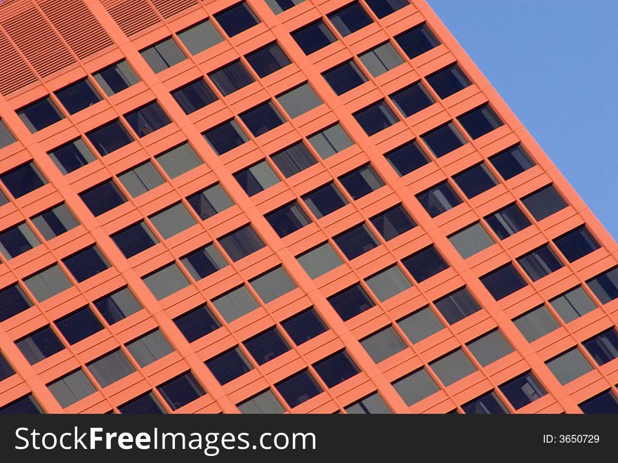 Red modern building of steel and concrete set against the blue sky. Red modern building of steel and concrete set against the blue sky