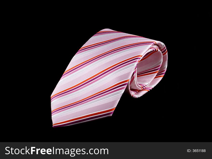 Pink striped tie on a black background. Pink striped tie on a black background.
