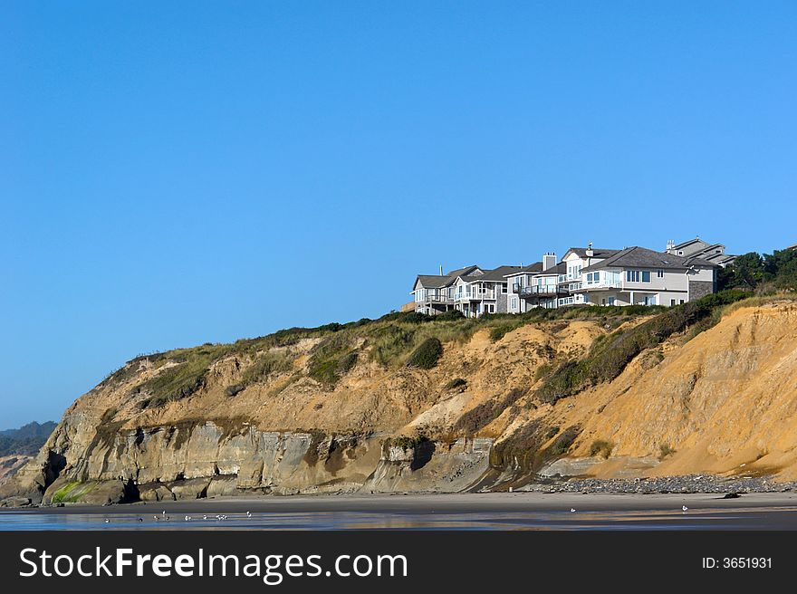 Houses nestled on top of a sandy cliff on the coast of oregon. Houses nestled on top of a sandy cliff on the coast of oregon
