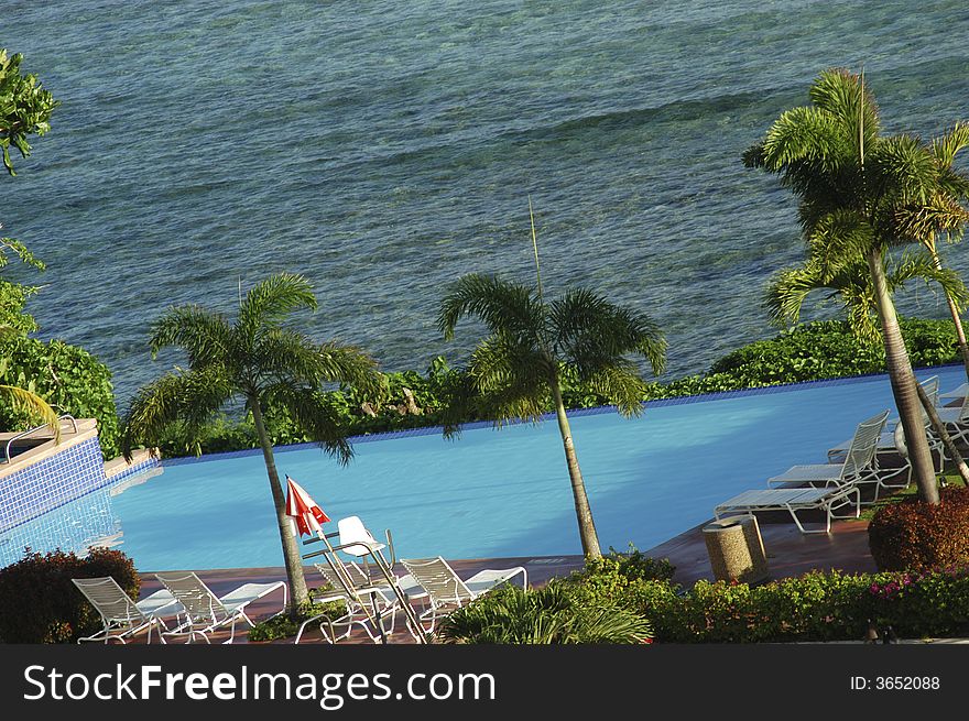 A hotel pool near the ocean shoreline. A hotel pool near the ocean shoreline.