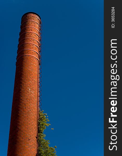 Tall red brick factory chimney