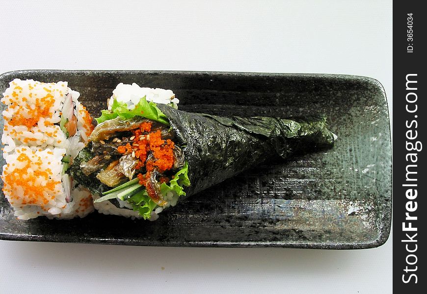 Sushi on the white background. Salmon skin torch in the black disk volumes yard and Alaska