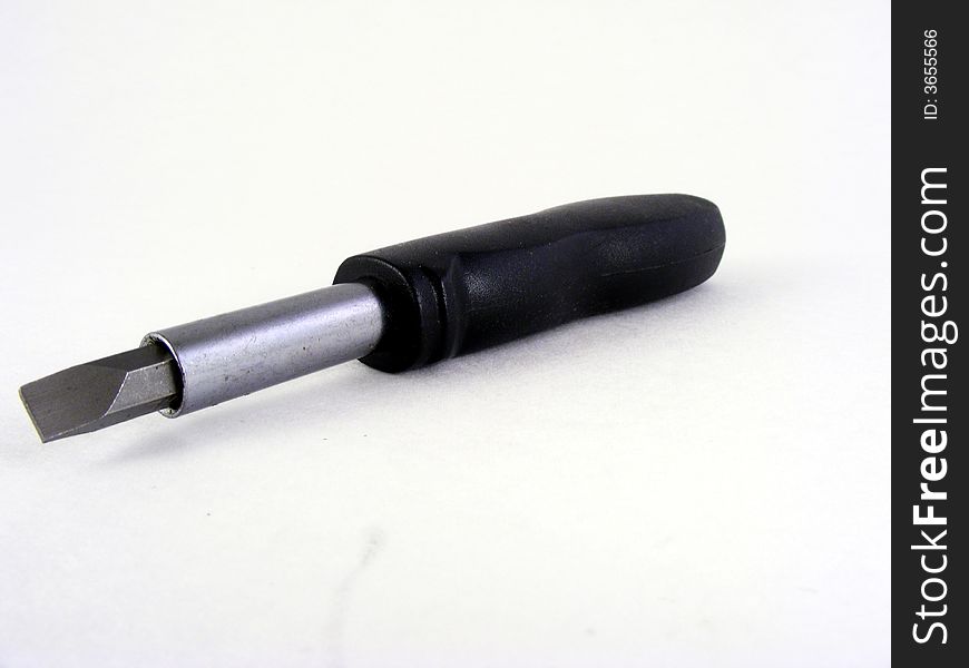 A flat handled, changeable head screwdriver against a white background. A flat handled, changeable head screwdriver against a white background.