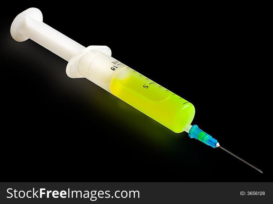 Syringe with green fluorescent liquid isolated on black. Syringe with green fluorescent liquid isolated on black.