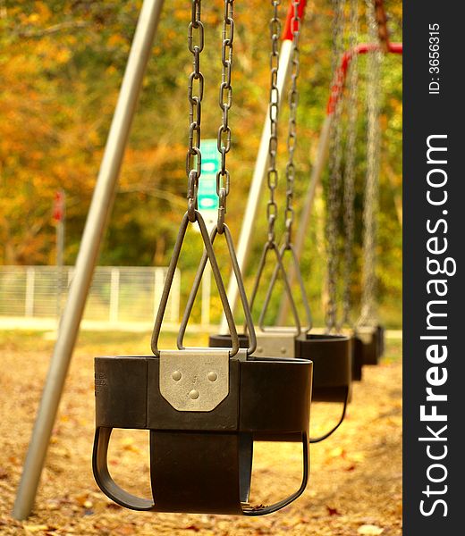 Empty swings in a row at a playground