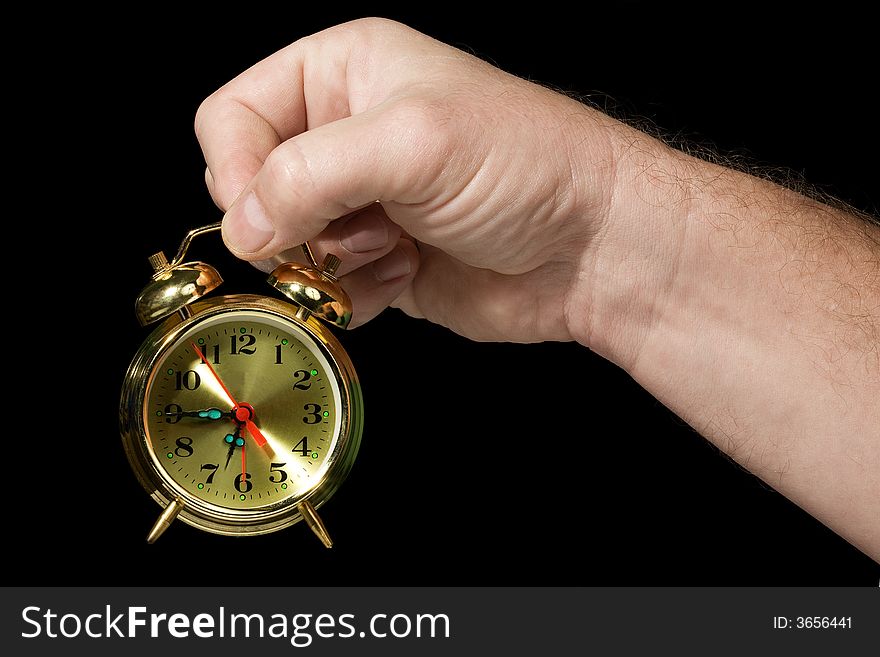 Alarm clock in a hand. Black background. The concept of time. Alarm clock in a hand. Black background. The concept of time.