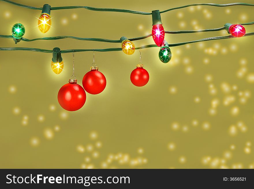 Three red christmas balls hanging on a set of colored tree lights. Three red christmas balls hanging on a set of colored tree lights