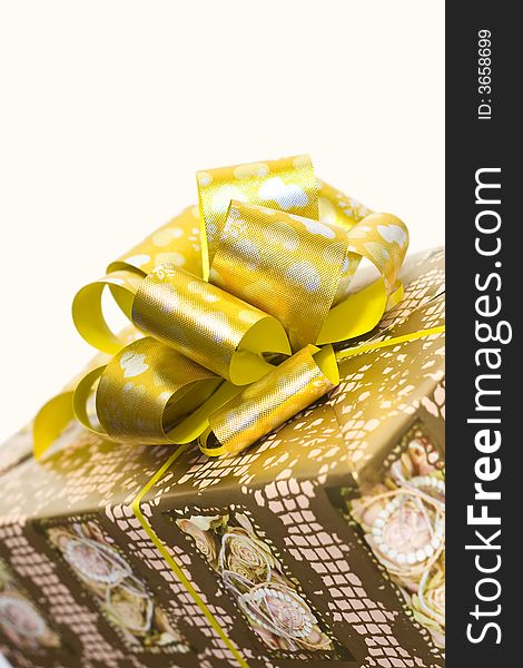 Detail of a gift box with golden ribbon and bow