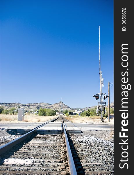 Railroad tracks running through a small town surrounded by a harsh arid environment.