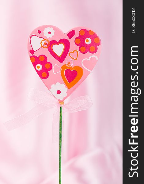 Pink handmade heart over pink background