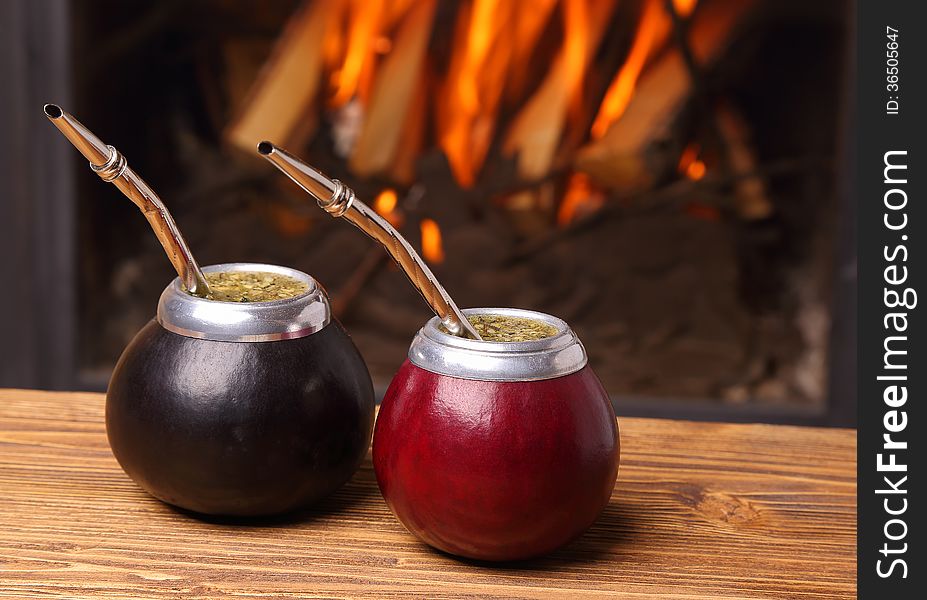 Hot mate in calabashes on the background the fireplace