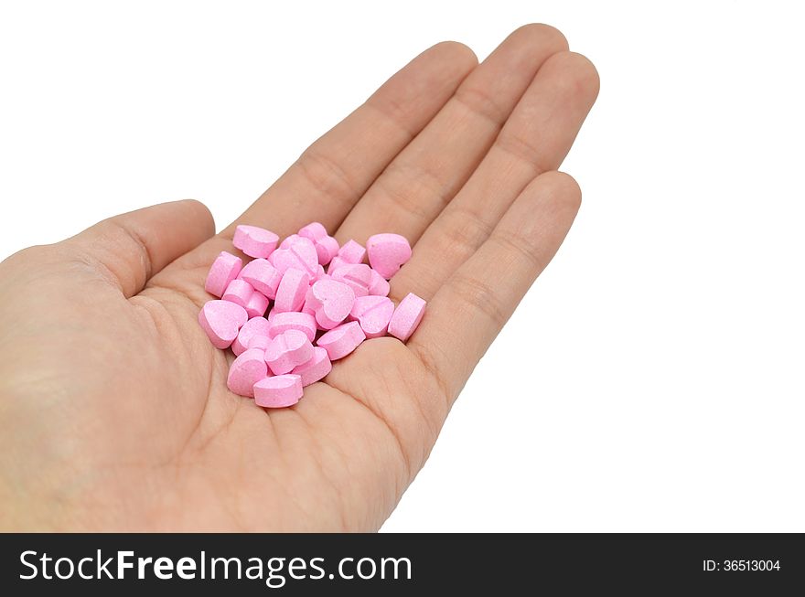 Closeup of woman hand holding heart pill