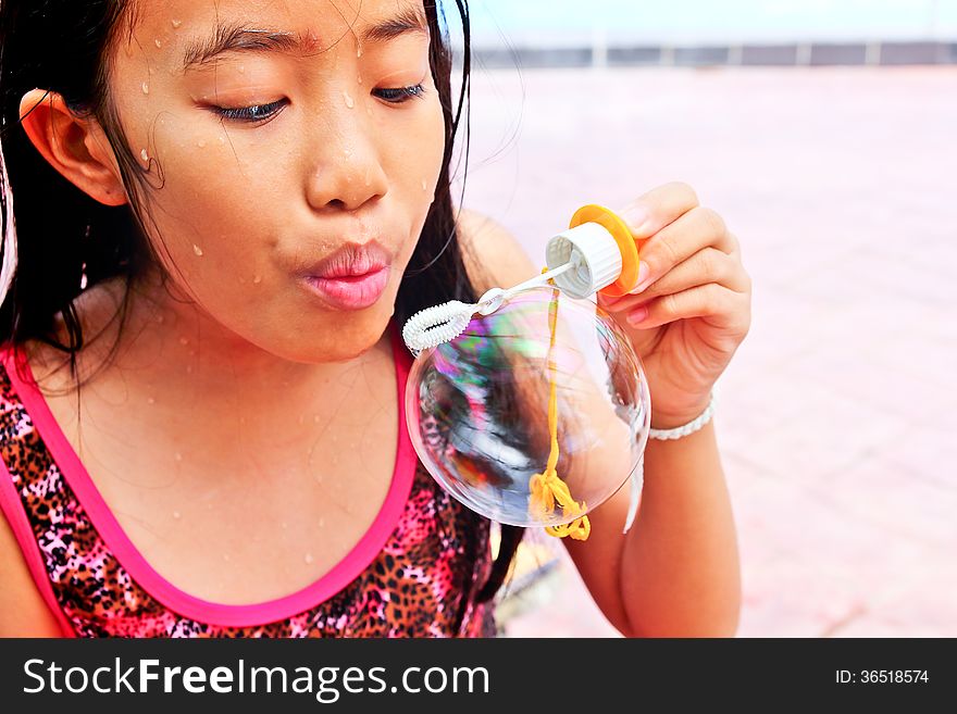 Asian girl blowing bubble at the pool. Asian girl blowing bubble at the pool