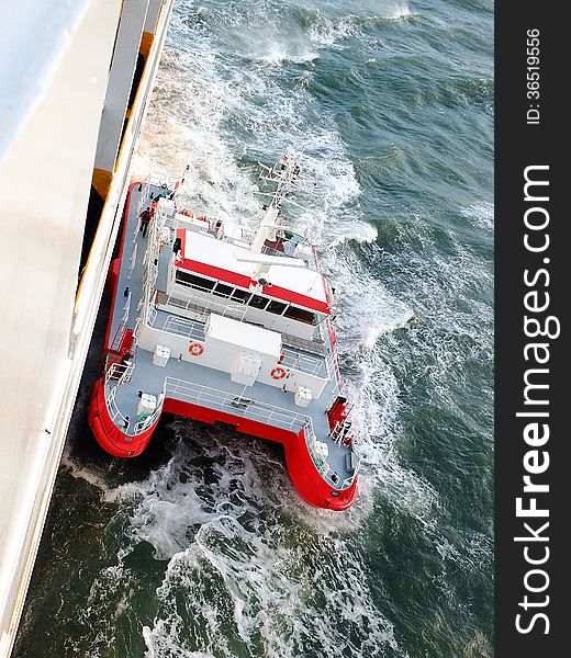 Pilot boat approaching a big ship