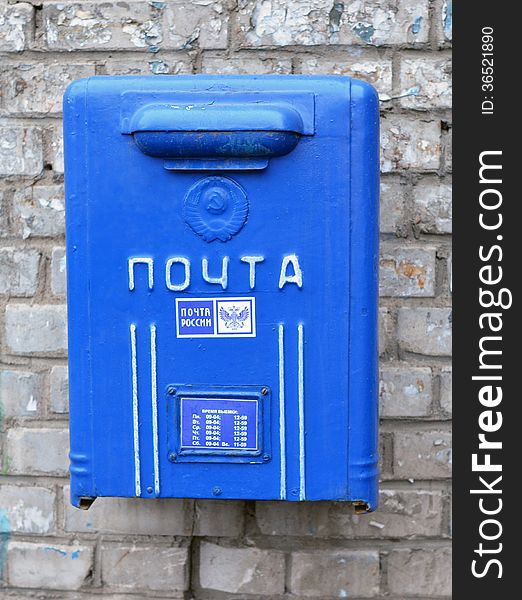 Old blue street mailbox on a building wall