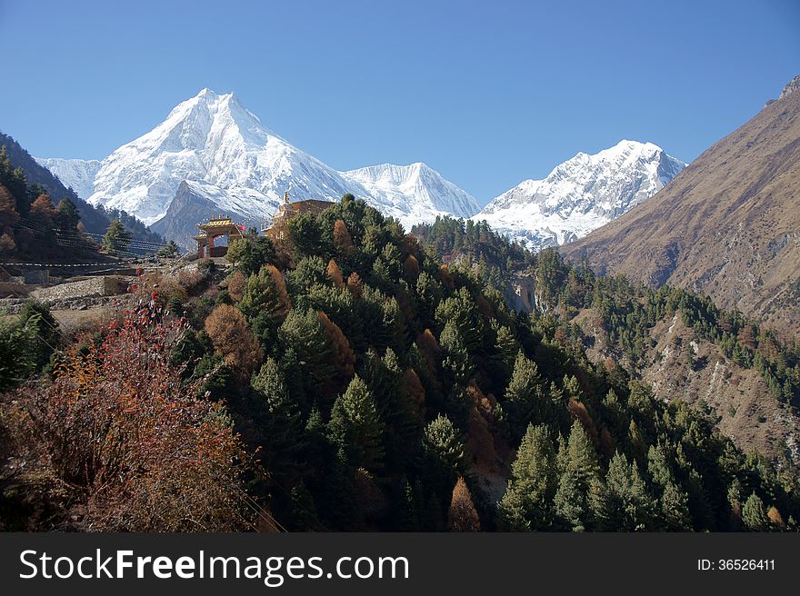 Mountain landscape with the Buddhist monastery on the background of snowy peaks