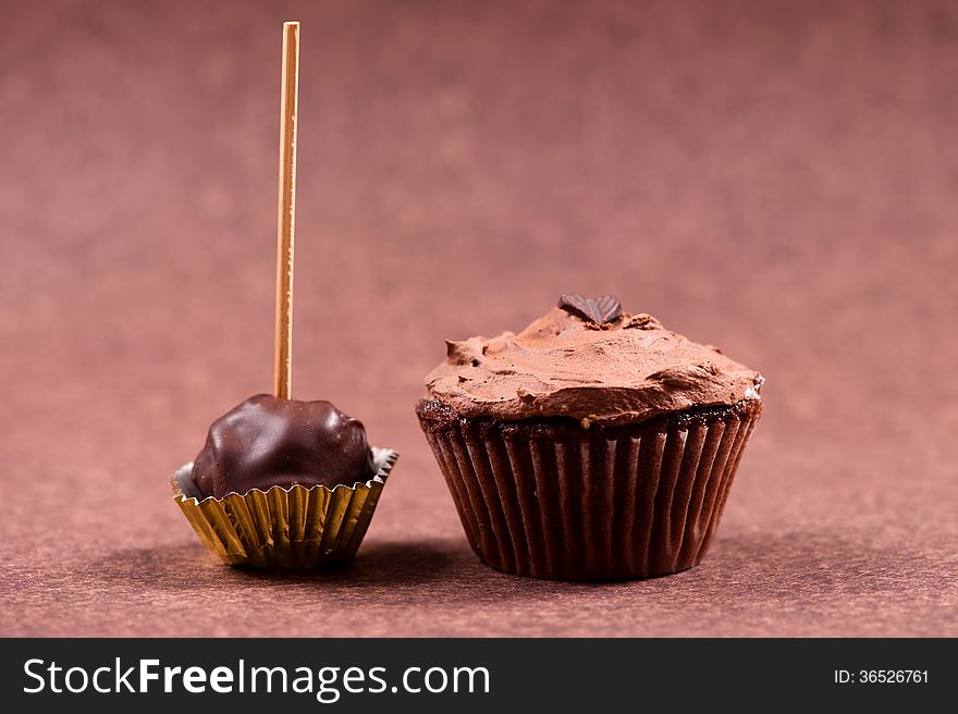 Chocolate muffin with hazelnut minty cream and ice cream topping isolated on brown background