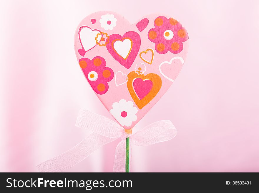 Pink handmade heart over pink background