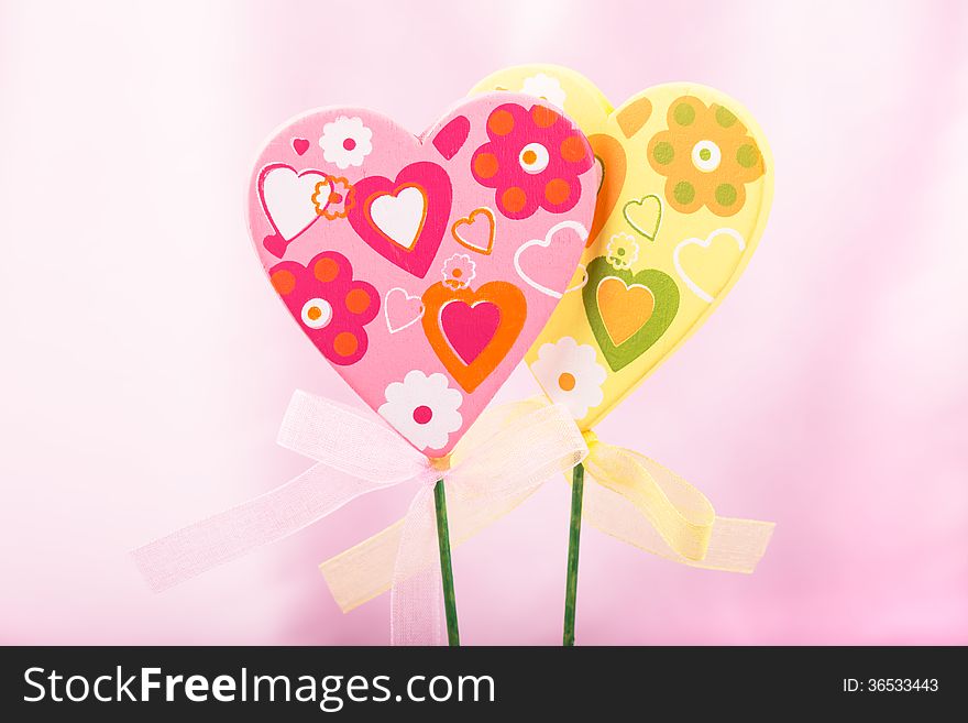 Pink and yellow handmade hearts over pink background