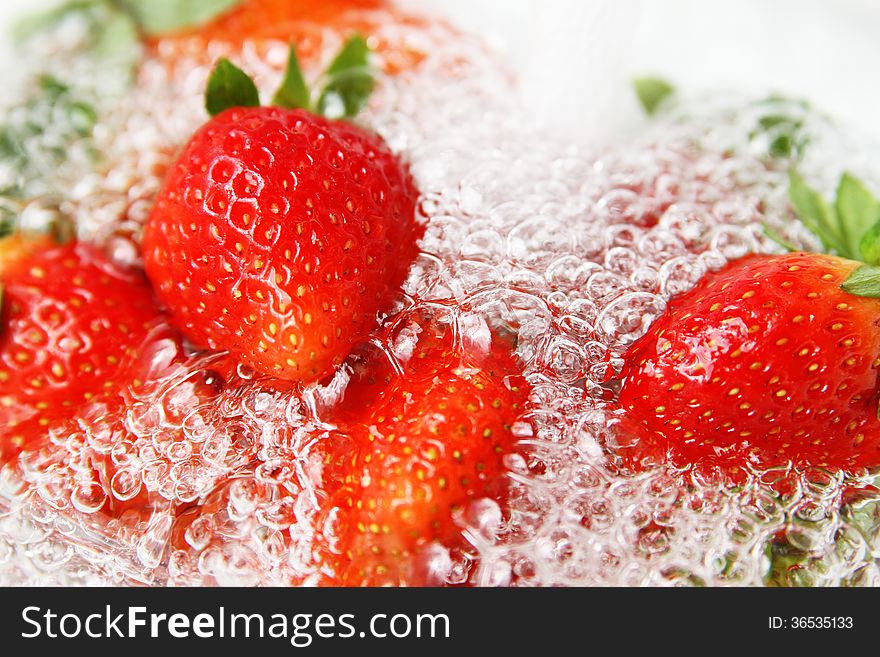 Fresh strawberries with water bubbles on white