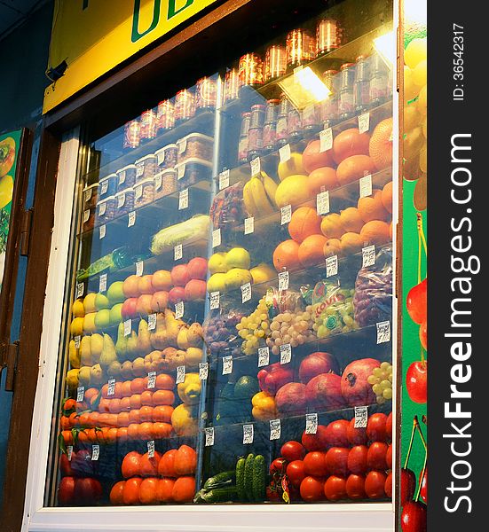 Fruit and vegetables behind the glazed show-window of a stall. Fruit and vegetables behind the glazed show-window of a stall