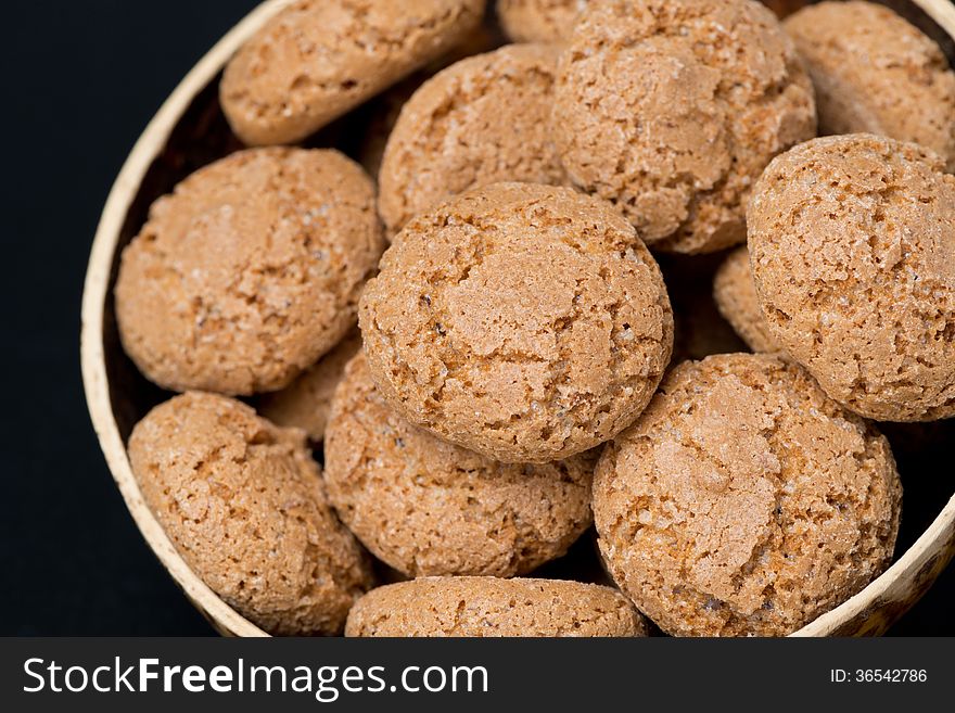 Biscotti cookies in a bowl on a black background, close-up