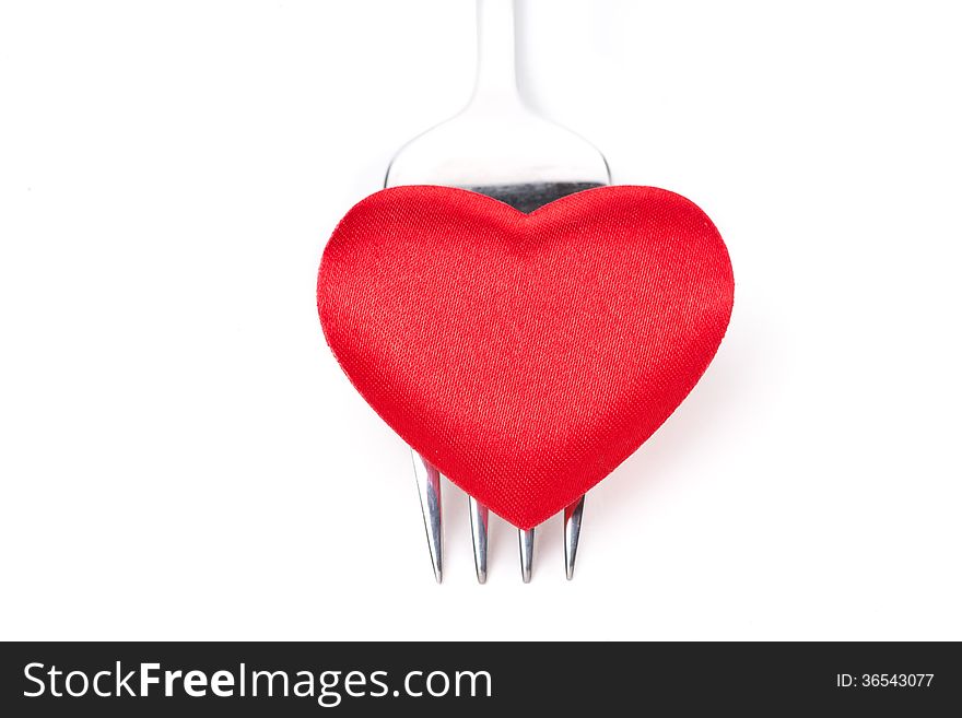 Red heart on a fork, concept, close-up, isolated on white