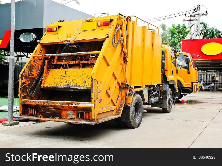 Yellow garbage truck service in the city