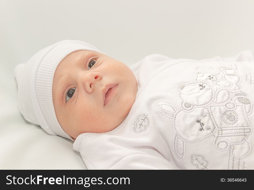 Babe in white a cap lies on white background. Babe in white a cap lies on white background