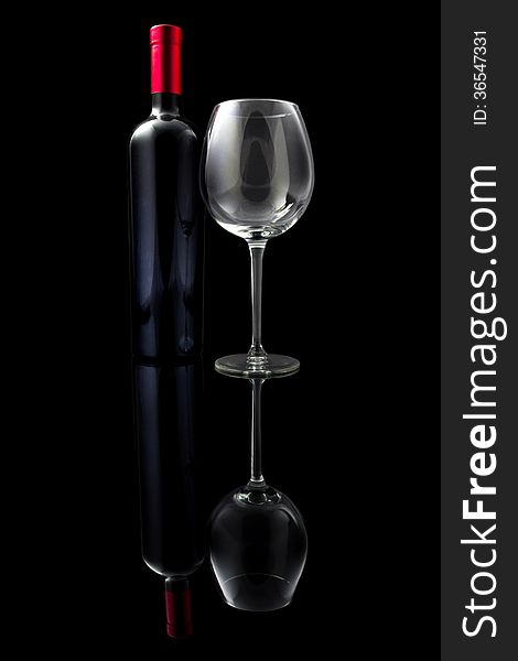 Red wine and empty glass isolated on black background