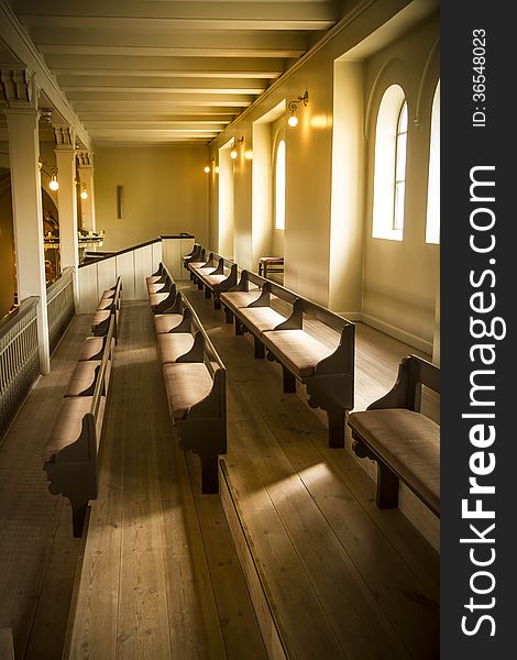 Warm natural light on lines of church pews at place of worship