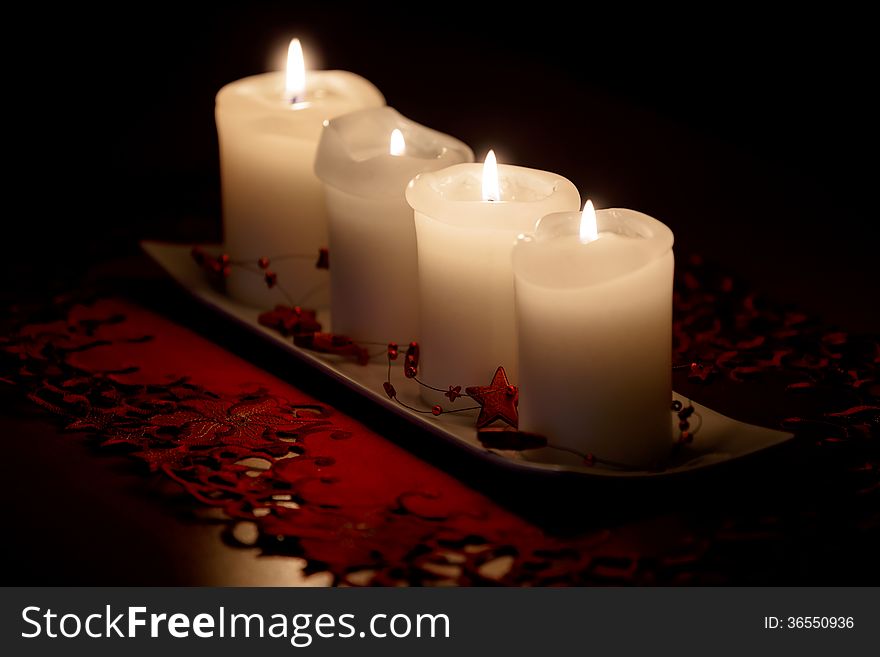 Burning candle and Christmas decorations on wooden table, on dark background. Burning candle and Christmas decorations on wooden table, on dark background