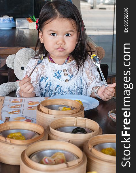 Little 2 year old girl eating Dim sum. Little 2 year old girl eating Dim sum.