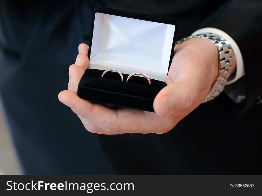 Man holding wedding rings in black box. Man holding wedding rings in black box