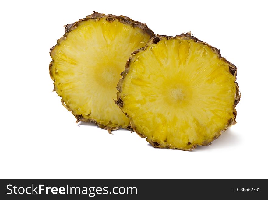 Two large slices of pineapple and two small slices. Presented on a white background. Two large slices of pineapple and two small slices. Presented on a white background.