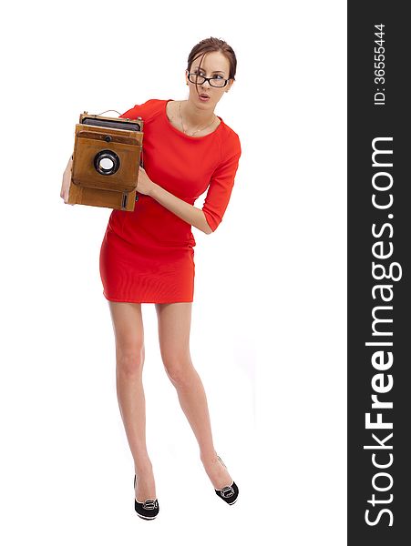 Girl in red dress with an old camera on a white background