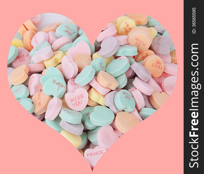 A bunch of candy hearts arranged in the shape of a heart.