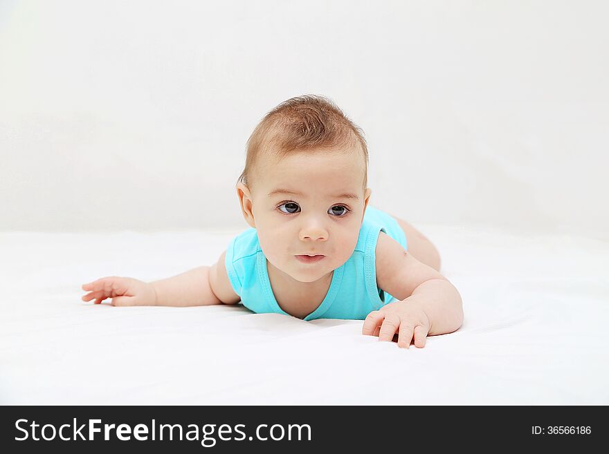 Baby boy laying on bed, white background