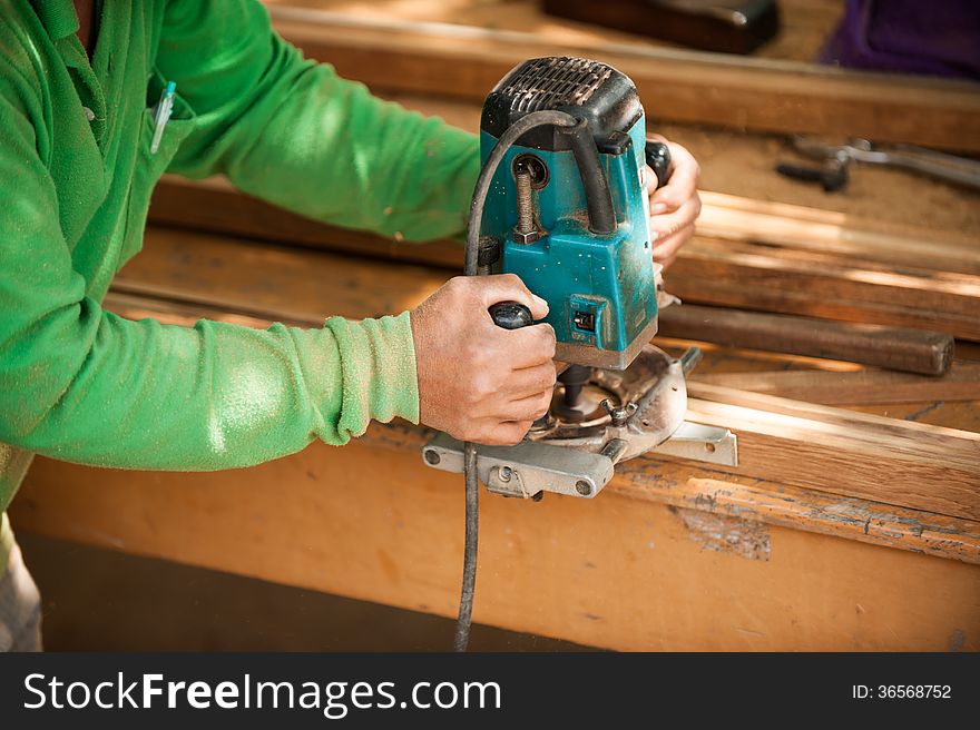 Hands of a carpenter planed wood, workplace