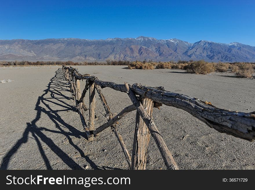 Old Wooden Fence In Desert By Mountains