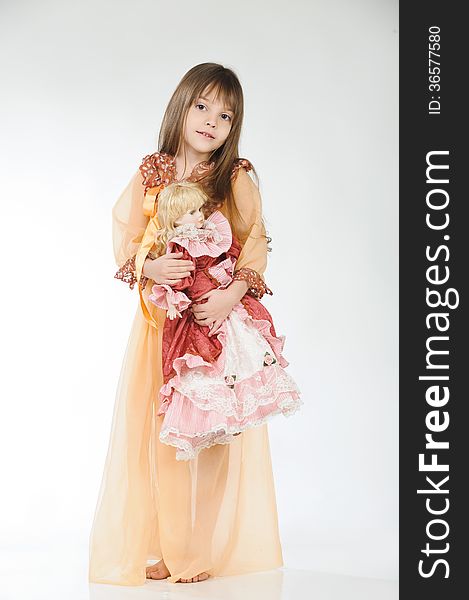 Studio photo. Girl holding a doll on a light background. Studio photo. Girl holding a doll on a light background