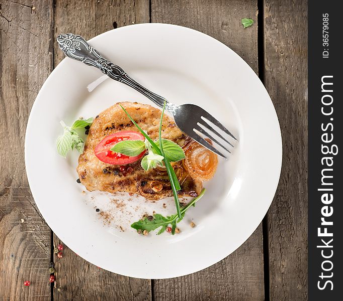 Fried meat on a plate on a wooden table