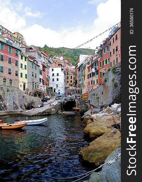 Cliff, boats and colored houses of Riomaggiore in Italy