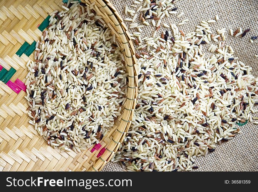 Raw brown rice on basket and sackcloth