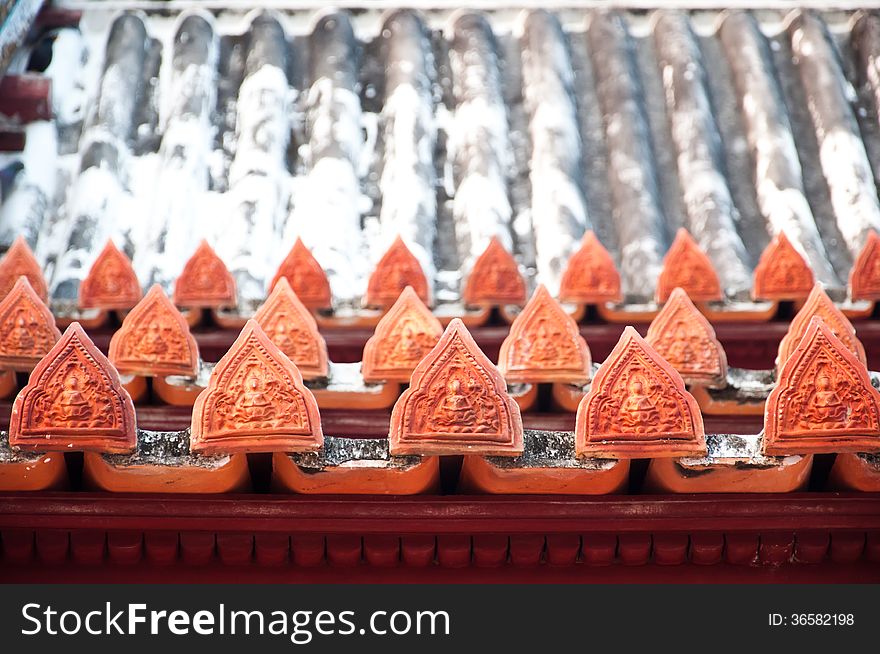 The angle pottery in Thai style decorate on the ancient roof of Temple at Yai Suwannaram temple in Petchaburi, Thailand